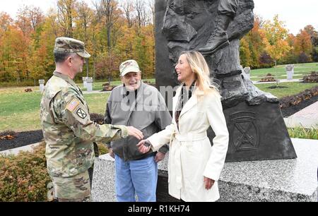 Maj. Gen. Walter E. Piatt, 10th Mountain Division (LI) and Fort Drum commanding general, presents a commander's coin to Robert Huni and his daughter Mary Ryan, during their visit Oct. 17 at Fort Drum, New York. Ryan, a North Syracuse resident and Syracuse Team Red, White and Blue member, ran the inaugural Memorial to Monument Run from Fort Drum to Watertown in September in honor of her father. ( Stock Photo