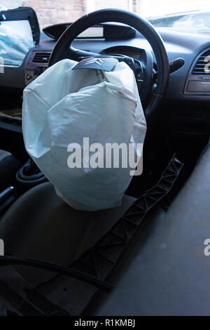 airbags deployed and exploded in written off crash damaged citroen c4 car on a recovery trailer Stock Photo
