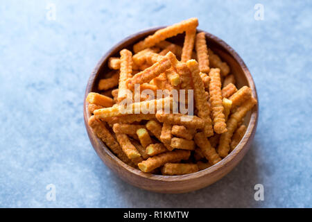 Orange Cheese Flavored Corn Snacks in Stick Shape / Roasted Chips or Salty Crackers in Wooden Bowl. Organic Roasted Snacks. Stock Photo
