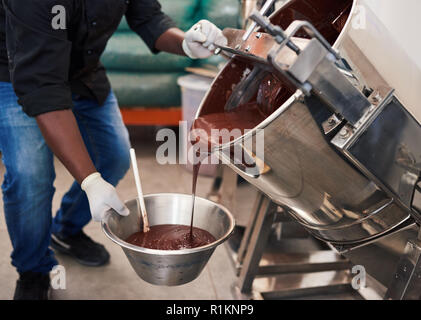 Worker melting chocolate while at work in a confectionary factory Stock Photo