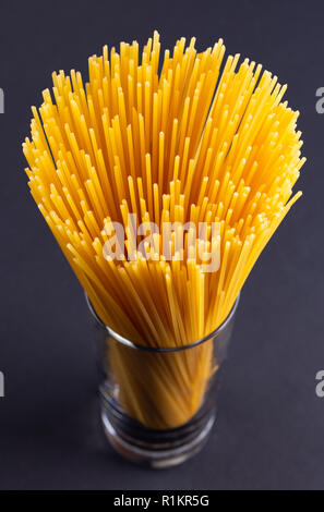 A bouquet of spaghetti in glass on a dark background Stock Photo