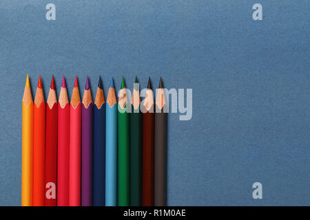 Multicolored pencils lie on a blue background Stock Photo