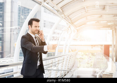 businessman talking business seriously on phone outside office Stock Photo
