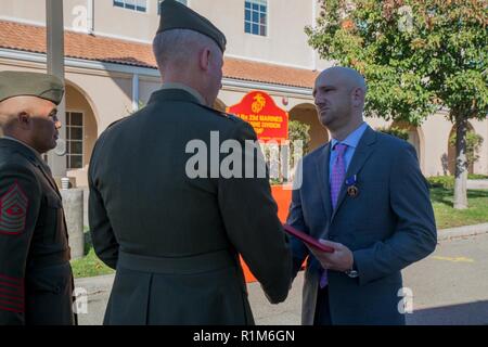 Marine veteran Matthew R. Follett (right), is presented with the Purple Heart by Col. Justin J. Anderson, battalion Inspector Instructor for 2nd Battalion, 23rd Marine Regiment, 4th Marine Division (center) and Sgt. Maj. Israel Rivera, battalion sergeant major of 2nd Bn., 23rd Marines, 4th MarDiv (left) in Pasadena, Calif. on October 19, 2018. SSgt Follett received the award for injuries sustained while serving as an active duty counter intelligence specialist with 3rd Battalion, 4th Marine Regiment, 1st Marine Division, on January 7, 2010. Stock Photo