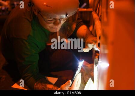 NORWEGIAN SEA (Oct. 20, 2018) Aviation Support Equipment Technician 3rd Class Aiden Hanno replaces a hose on a spotting dolly in the hangar bay aboard the Nimitz-class aircraft carrier USS Harry S. Truman (CVN 75). Currently operating in the U.S. Sixth Fleet area of operations, Harry S. Truman will continue to foster cooperation with regional allies and partners, strengthen regional stability, and remain vigilant, agile and dynamic. Stock Photo