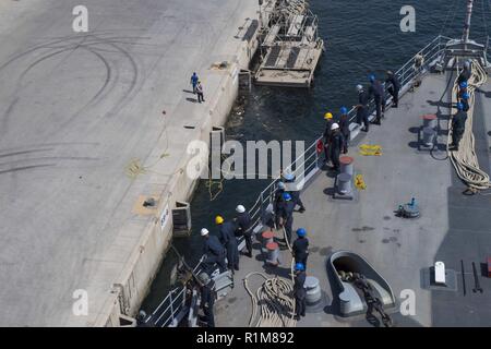 JEBEL ALI, United Arab Emirates (Oct. 13, 2018) Sailors aboard Whidbey Island-class dock landing ship USS Rushmore (LSD 47) prepare to anchor in the port of Jebel Ali during a deployment of the Essex Amphibious Ready Group (ARG) and 13th Marine Expeditionary Unit (MEU). The Essex ARG/13th MEU is a lethal, flexible, and persistent Navy-Marine Corps team deployed to the U.S. 5th Fleet area of operations in support of naval operations to ensure maritime stability and security in the Central Region, connecting to the Mediterranean and the Pacific through the western Indian Ocean and three strategi Stock Photo