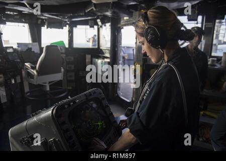 ARABIAN GULF (Oct. 13, 2018) Operations Specialist 3rd Class Dacia Andrade stands watch in the pilot house of Whidbey Island-class dock landing ship USS Rushmore (LSD 47) during a regularly scheduled deployment of the Essex Amphibious Ready Group (ARG) and 13th MEU. The Essex ARG/13th MEU is lethal, flexible, and persistent Navy-Marine Corps team deployed to the U.S. 5th Fleet area of operations in support of naval operations to ensure maritime stability and security in the Central Region, connecting to the Mediterranean and the Pacific through the western Indian Ocean and three strategic chok Stock Photo