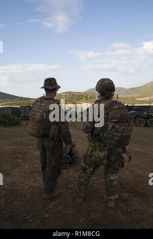 SARDINIA, Italy (Oct. 13, 2018) U.S. Marine Capt. Robert Atkinson, left, platoon commander for the Force Reconnaissance Det. of Battalion Landing Team 3/1, 13th Marine Expeditionary Unit (MEU), speaks to Sotto Tenente Vascello Chiara Bergamini, a platoon commander for the 1st Regiment San Marco Brigade, Italian Landing Force, before an integrated patrolling exercise during Mare Aperto, Oct. 13, 2018. Mare Aperto is designed to improve combined combat capability, increase operational capacity, and strengthen relationships among exercise participants. Stock Photo