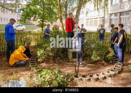 Members of Kaiserslautern area Boy Scout Troop 232 work on a student memorial restoration project led by Nathan Perez on October 6, 2018 at what is now Kaiserslautern Middle School.  While this is Perez’s Eagle Scout project, it is meant to honor the memory of Erick Lynch, a Kaiserslautern American High School student and Boy Scout, who was killed in 1998, and to whom this statue was dedicated that year.  Over the years, the memorial had fallen into neglect. Stock Photo