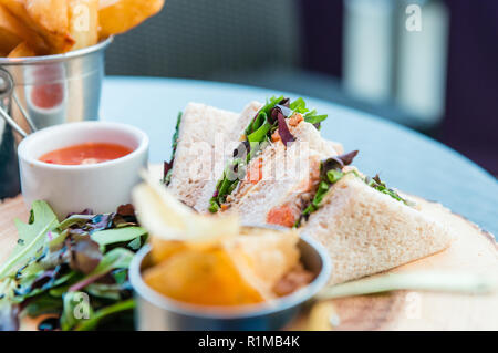 Crab sandwiches with salad and chips on top of a table in a cafe Stock Photo
