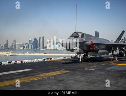 DOHA, QATAR (Oct. 14, 2018) An F-35B Lightning II, attached to the “Avengers” of Marine Fighter Attack Squadron (VMFA) 211, is chocked and chained on the flight deck as the Wasp-class amphibious assault ship USS Essex (LHD 2) arrives in Doha, Qatar. USS Essex is a flexible, and persistent Navy-Marine Corps team deployed to the U.S. 5th Fleet area of operation in support of naval operations to ensure maritime stability and security in the Central Region, connecting the Mediterranean and the Pacific through the western Indian Ocean and three strategic choke points. Stock Photo