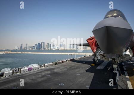 DOHA, QATAR (Oct. 14, 2018) An F-35B Lightning II, attached to the “Avengers” of Marine Fighter Attack Squadron (VMFA) 211, is chocked and chained on the flight deck as the Wasp-class amphibious assault ship USS Essex (LHD 2) arrives in Doha, Qatar. USS Essex is a flexible and persistent Navy-Marine Corps team deployed to the U.S. 5th Fleet area of operation in support of naval operations to ensure maritime stability and security in the Central Region, connecting the Mediterranean and the Pacific through the western Indian Ocean and three strategic choke points. Stock Photo