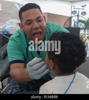 ESMERALDAS, Ecuador (Oct. 23, 2018) – Chief Hospital Corpsman Orlando Atencia, from Miami, performs a dental examination at one of two medical sites. The hospital ship USNS Comfort (T-AH 20) is on an 11-week medical support mission to Central and South America as part of U.S. Southern Command’s Enduring Promise initiative. Working with health and government partners in Ecuador, Peru, Colombia and Honduras, the embarked medical team will provide care on board and at land-based medical sites, helping to relieve pressure on national medical systems caused partly by an increase in cross-border mig Stock Photo