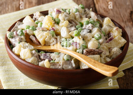 Latvian Baltic salad rasols made of vegetables, herring and beef, dressed with mayonnaise close-up in a bowl on the table. horizontal Stock Photo