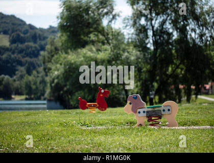 Children's playground with rocker horse and lion at Pleschinger See/ lake in Linz, Upper Austria Stock Photo