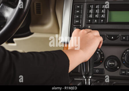 Cropped shot of woman changing gear while driving car Stock Photo