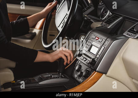Cropped shot of woman changing gear while driving new car Stock Photo