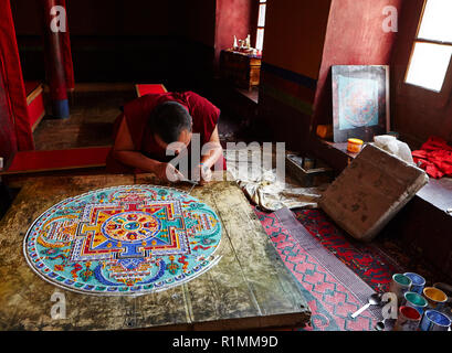 Buddhist monk creating a mandala of color sand in Lamayuru monastery. Ladakh, Jammu and Kashmir, India Stock Photo