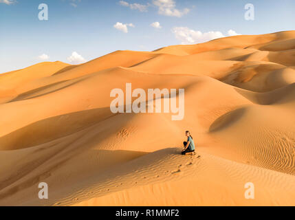 person in the middle of bog dunes of Liwa desert in Abu Dhabi Stock Photo