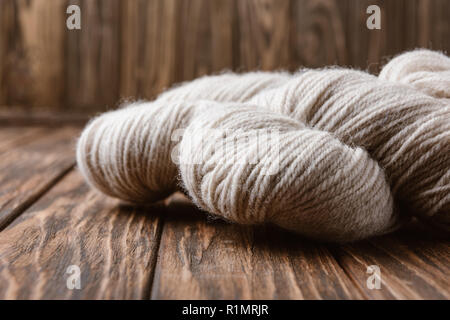 close up view of white yarn for knitting on wooden surface Stock Photo