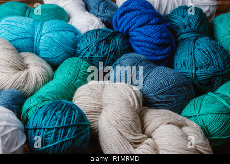 close up view of white, blue and green yarn for knitting as backdrop Stock Photo