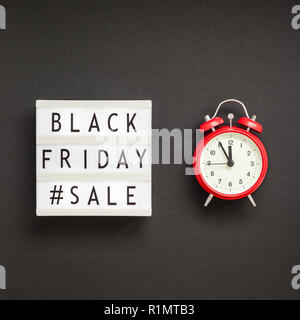 Creative Top view flat lay promotion composition Black friday sale text on lightbox alarm clock black background copy space Square Template Black frid Stock Photo
