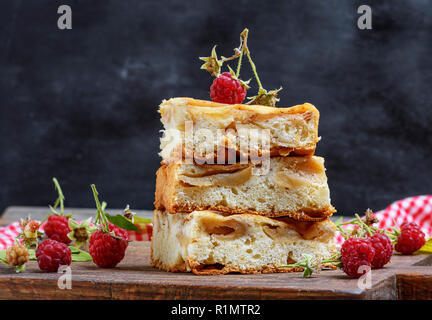 pieces of apple pie are stacked on a brown wooden board, sponge cake Stock Photo