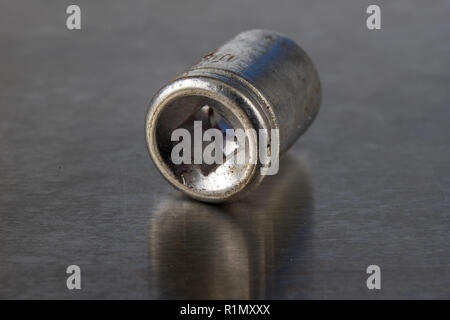 Old socket wrenches with a handle. Accessories for a workshop mechanic on a tin table. Light background. Stock Photo