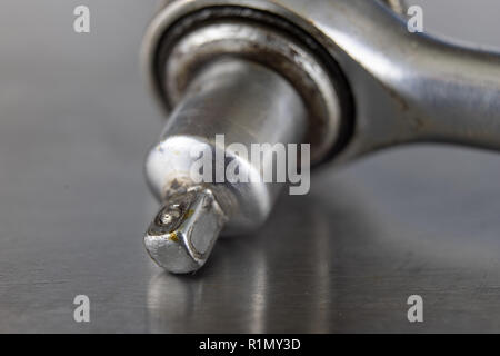 Old socket wrenches with a handle. Accessories for a workshop mechanic on a tin table. Light background. Stock Photo