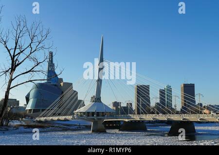Over the Red River. Winter view on Esplanade Riel bridge with Canadian Museum for Human Rights on the background. Winnipeg, Manitoba, Canada. Stock Photo