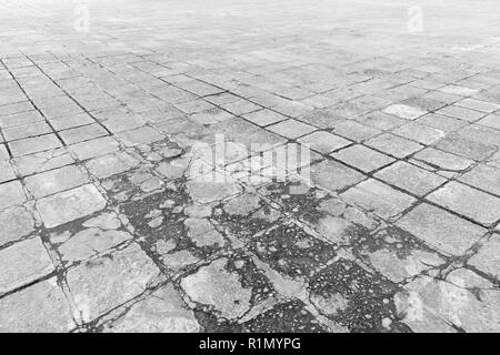 Full frame background of old and weathered cement paving slabs outdoors in black and white. Stock Photo