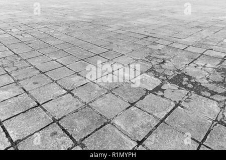 Full frame background of old and weathered cement paving slabs outdoors in black and white. Stock Photo
