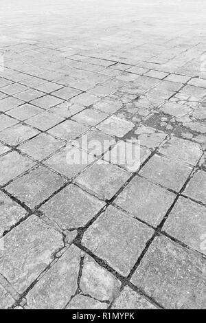 Full frame background of old and weathered cement paving slabs outdoors in black and white. Stock Photo