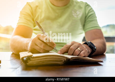 A young successful person taking notes in a personal journal Stock Photo