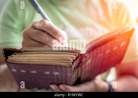 A young successful person taking notes in a personal journal Stock Photo