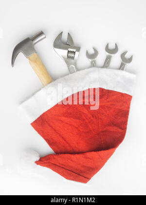 Hammer, adjustable wrench, wrenches in Santa Hat. Handy tools in Christmas festival background concept. Stock Photo