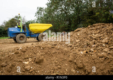 Yellow front tipper dumper working in construction site. Stock Photo
