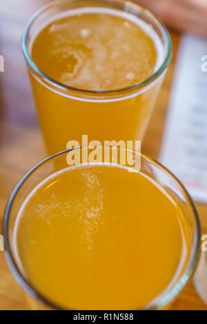 Close up of two tall glasses of beer on a table at a restaurant Stock Photo