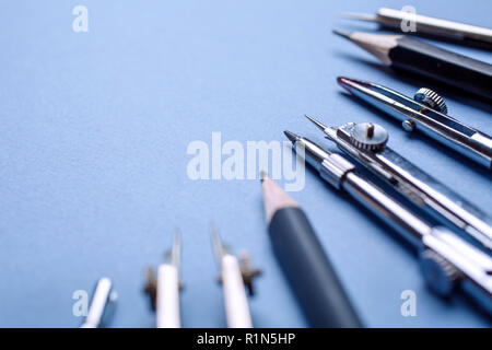The compass, along with other tools for drawing on the blue background Stock Photo