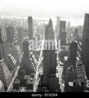 1950s, aerial view across Manhattan and New York City, showing a city landscape dominated by giant tower blocks and skyscrapers. On top of one of the tall buildings is a sign for Newsweek, a famous American weekly printed magazine founded in 1933. Stock Photo