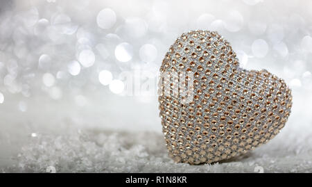 Christmas for valentines. Shiny heart on snow, abstract bokeh lights background, copy space Stock Photo