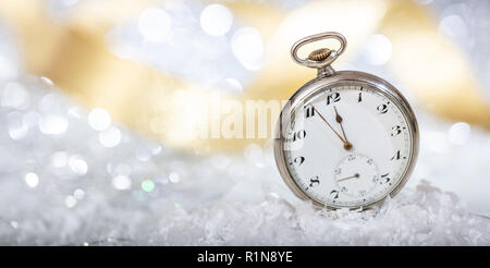 New Years eve countdown. Minutes to midnight on an old pocket watch, bokeh background, copy space Stock Photo