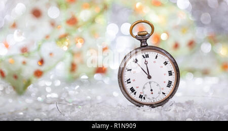 New Years eve countdown. Minutes to midnight on an old pocket watch, bokeh background, copy space Stock Photo