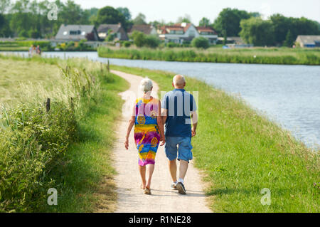 Elderly couple and a family walking along side de canal de Eem in Baarn and enjoying a warm summer day, the Netherlands Stock Photo