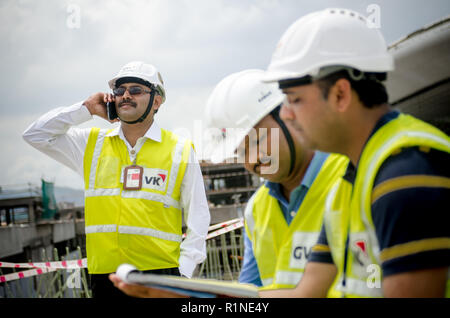 Safety officers working and talking over the phone at a construction site. Stock Photo