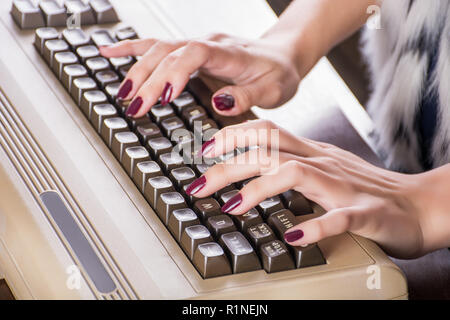Woman hands typing on old computer keyboard on desk in office. Retro and vintage information technology concept. Close up, selective focus Stock Photo