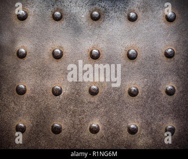 Rusty, studded cast iron vintage industrial plate background. Stock Photo