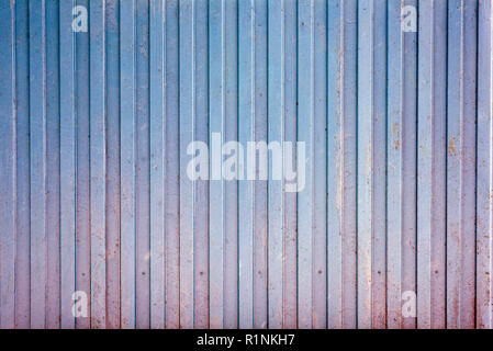 Insulated metal fence of blue color from corrugated sheet. Stock Photo