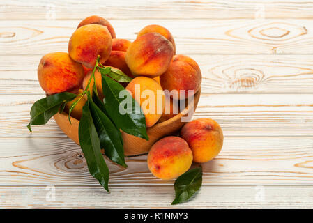 fresh peaches in a plate with leaves Stock Photo