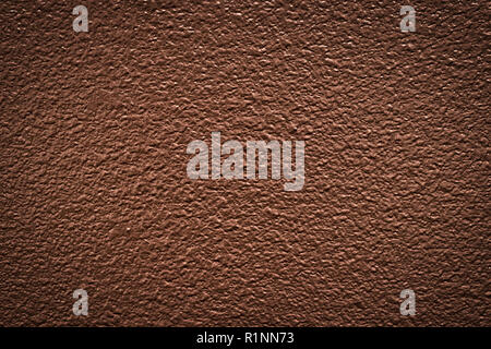 Textured brown wall paint from a house interior with a dramatic look and black vignetting around the corners. Stock Photo
